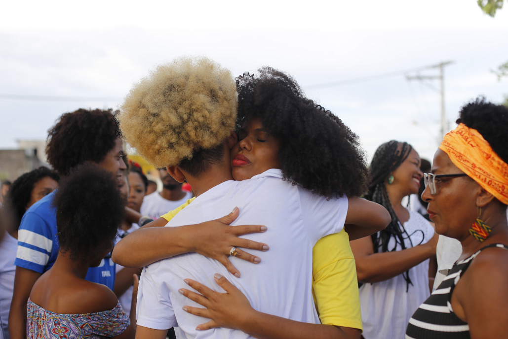 A antropóloga Naira Gomes, organizadora do ato, abraça o adolescente vítima de agressão