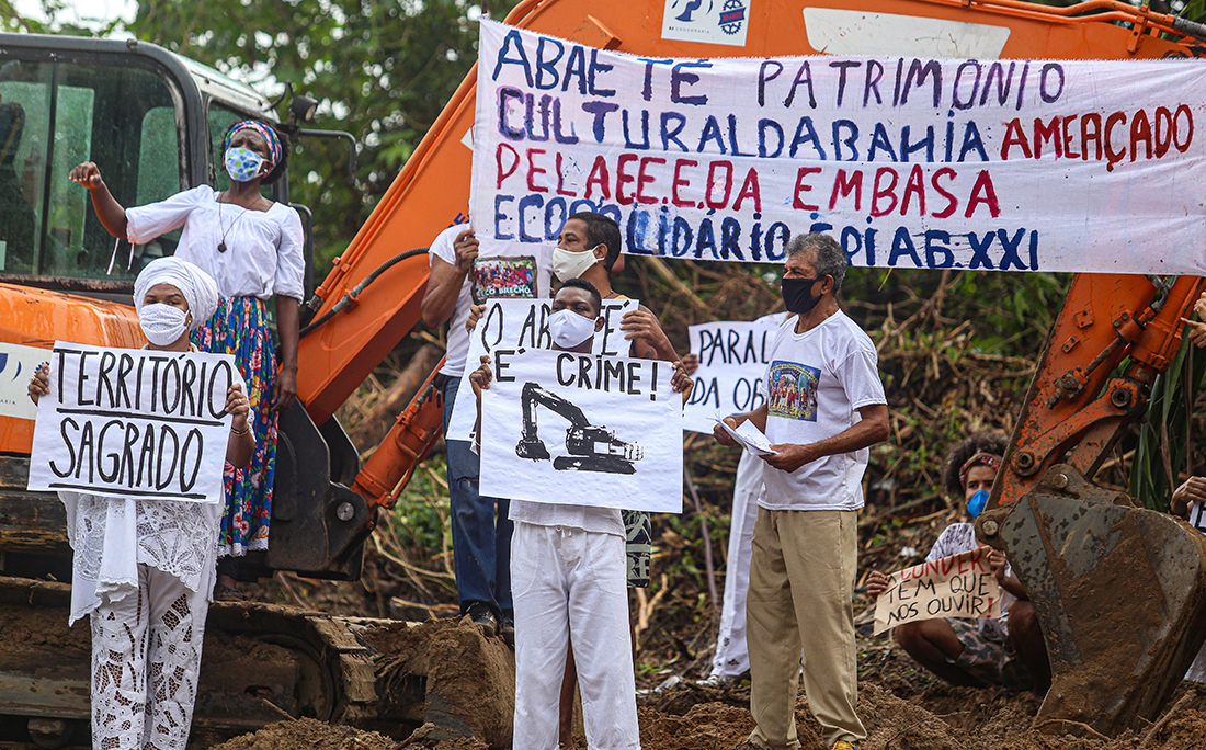 Manifestantes exibiam cartazes pedindo a paralisação da obra, respeito à cultura local e ao povo de matriz africana, que tem a lagoa um local sagrado.
