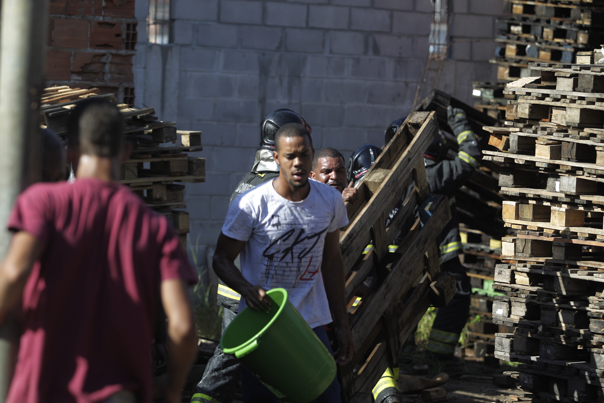 Moradores jogaram baldes de água para tentar impedir que o fogo atingisse casas vizinhas.